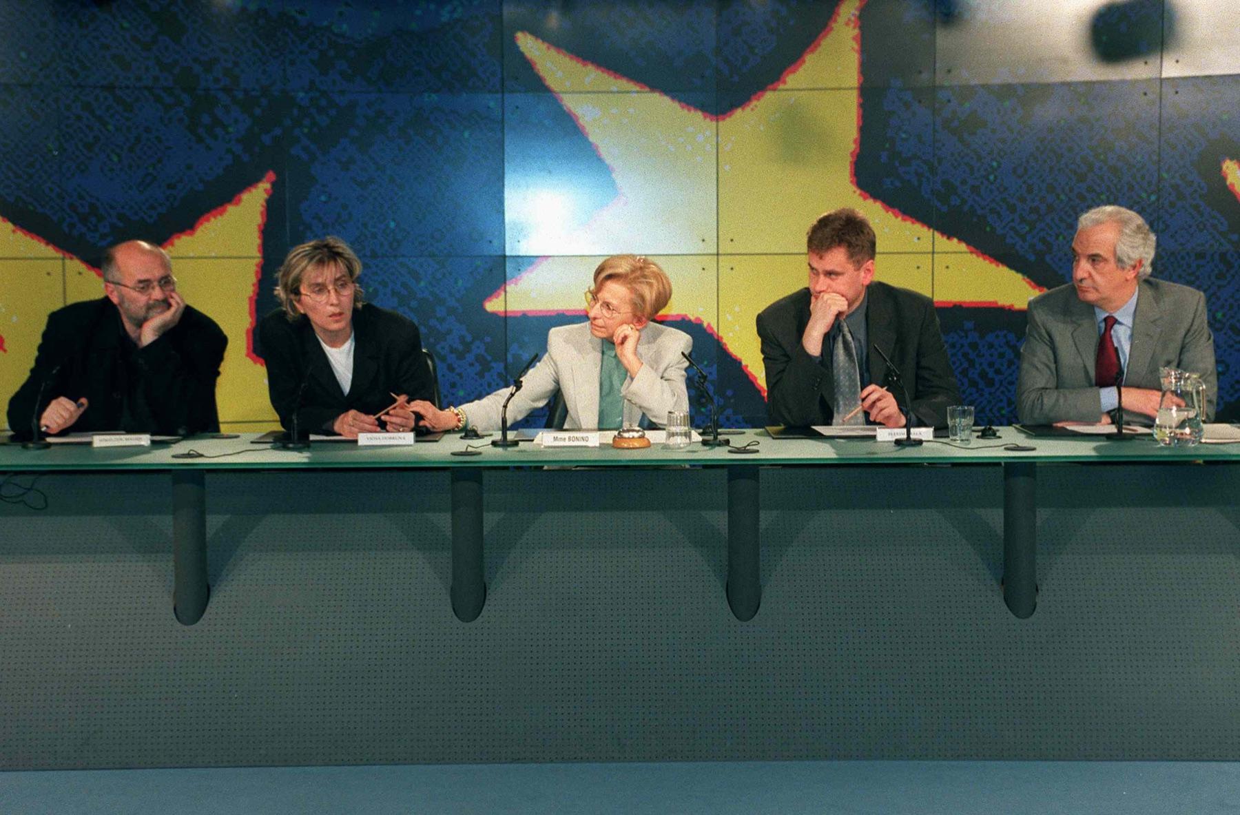 Four people at a press-conference table