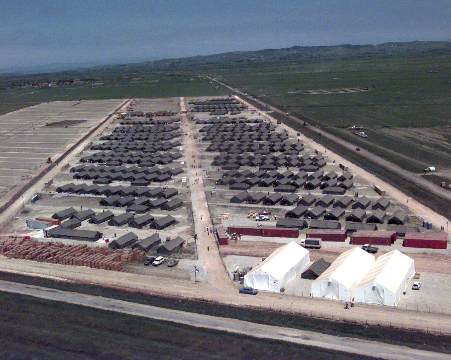 Hundreds of tents pitched in rows on a flat plain