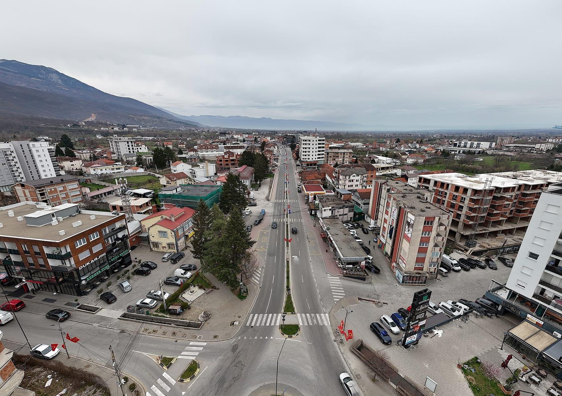 Aerial view of the main road and central buildings with mountains behind.