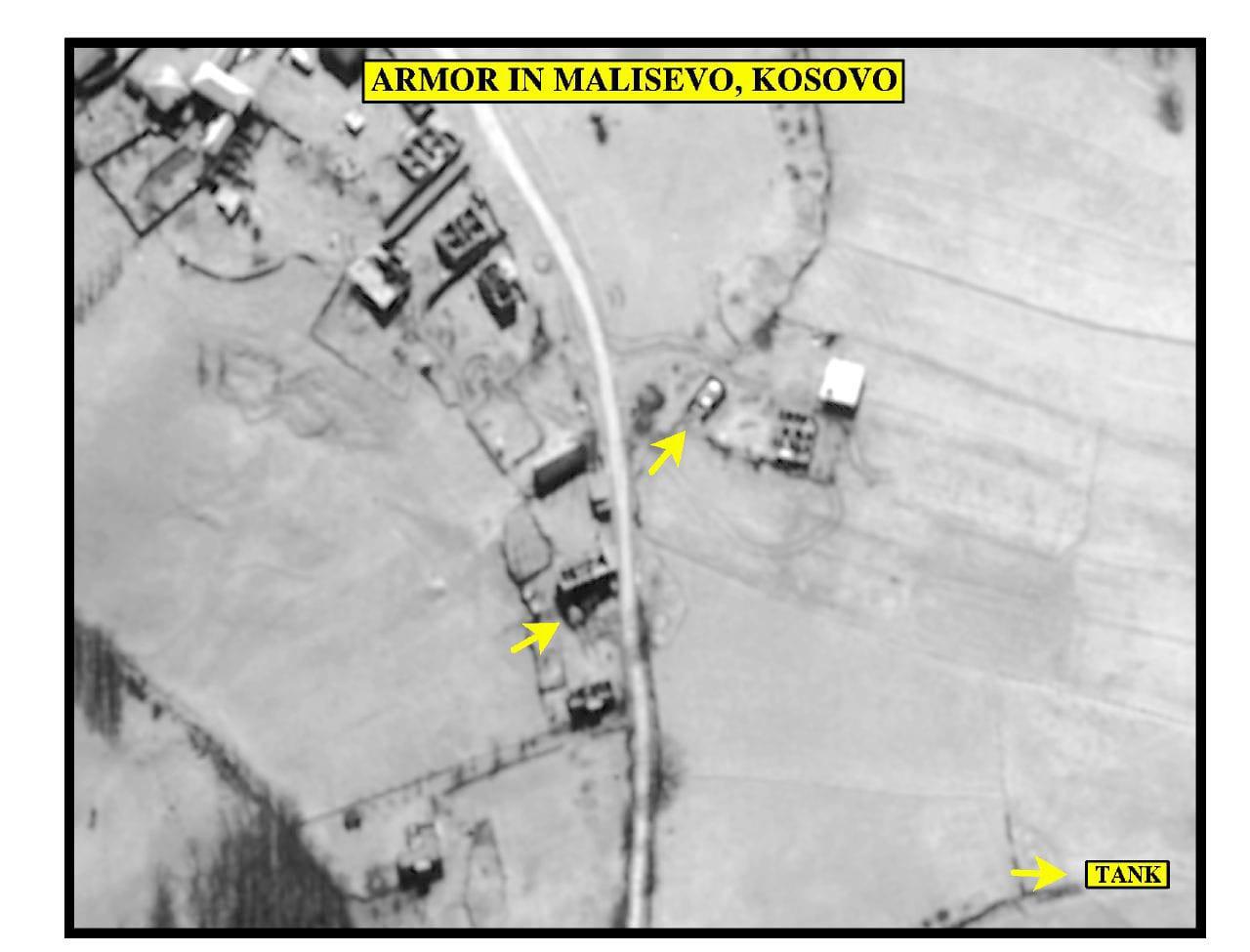 Black-and-white aerial image of a road and buildings with yellow arrows.