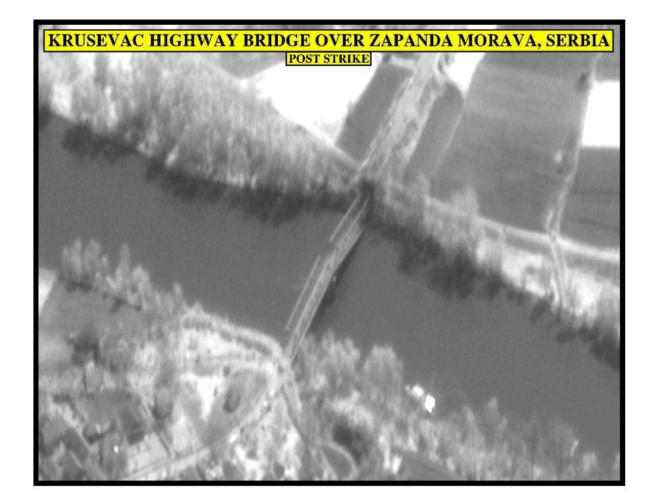 Black-and-white aerial view of a struck bridge over a river, with an identifying caption.