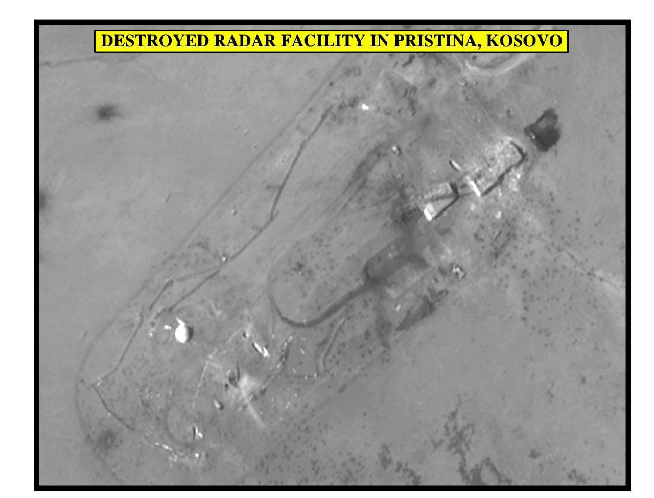 Black-and-white aerial view of a site with strike marks, with a yellow caption.
