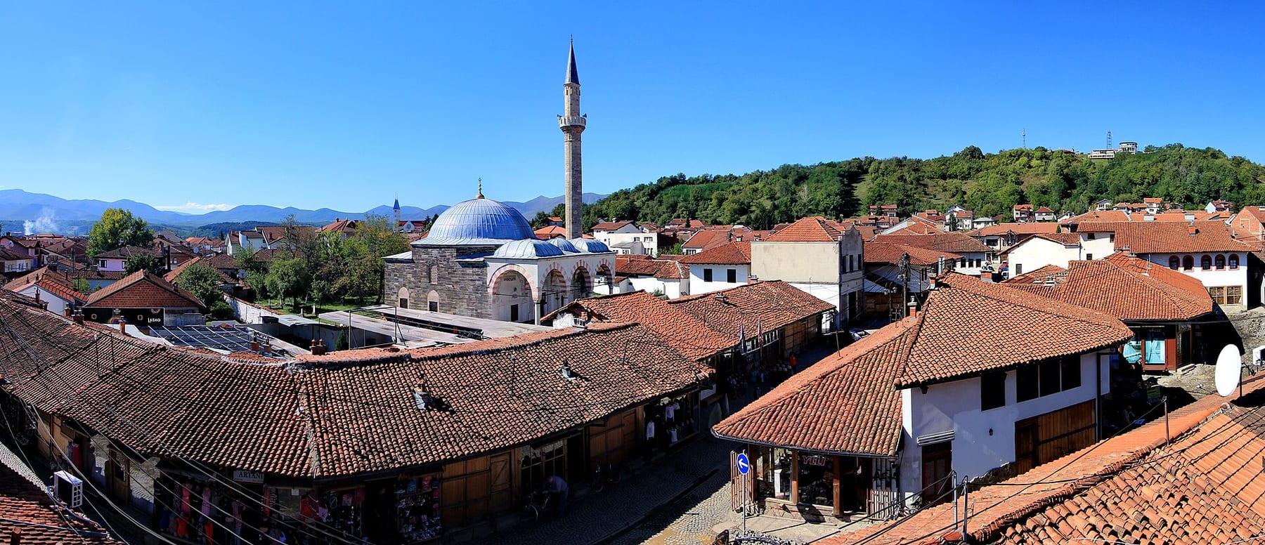 Red-tiled roofs of the old bazaar with the mosque's minaret and dome in the middle.