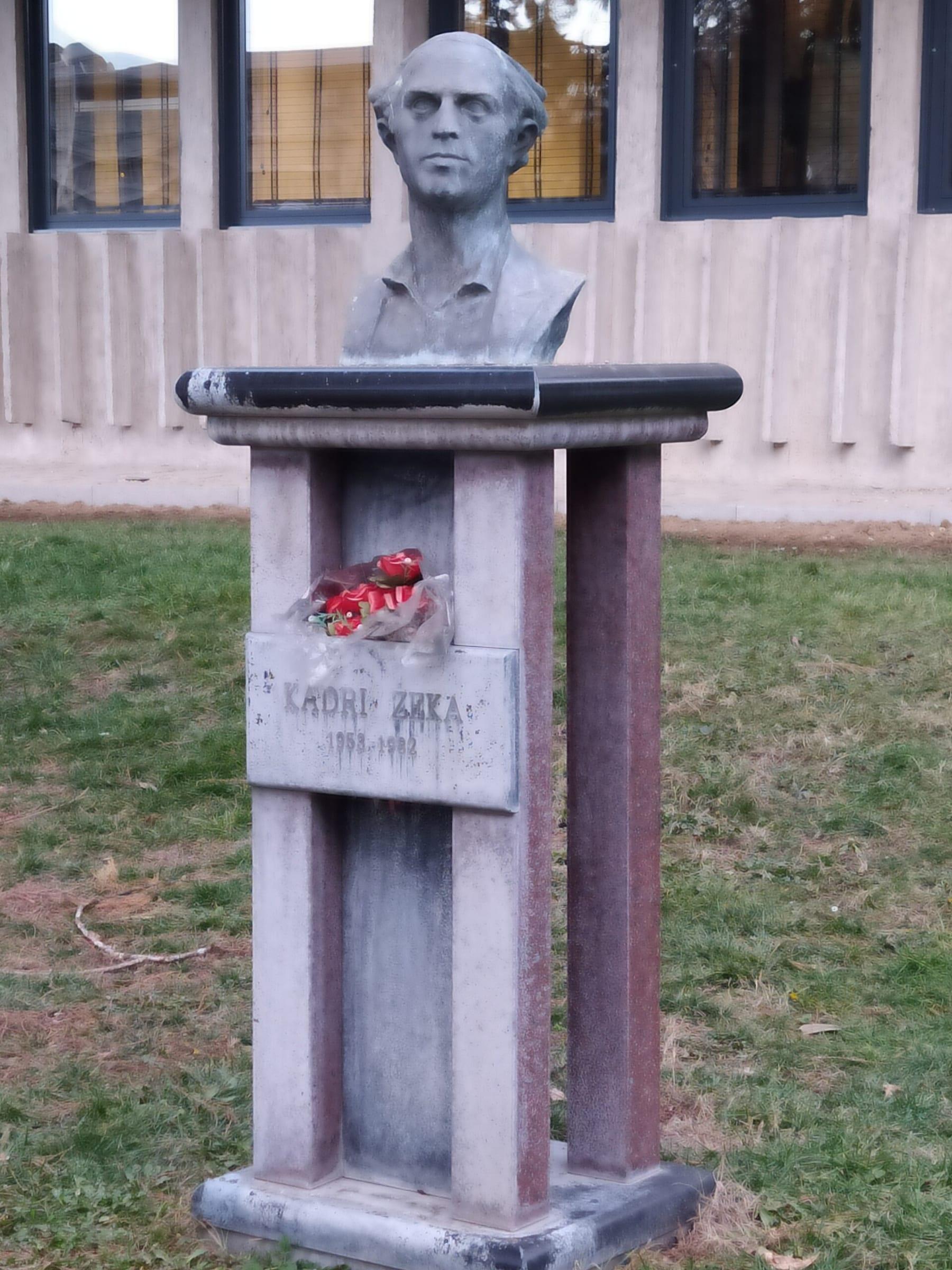 Stone bust on a plinth inscribed “Kadri Zeka”, with flowers laid on it.