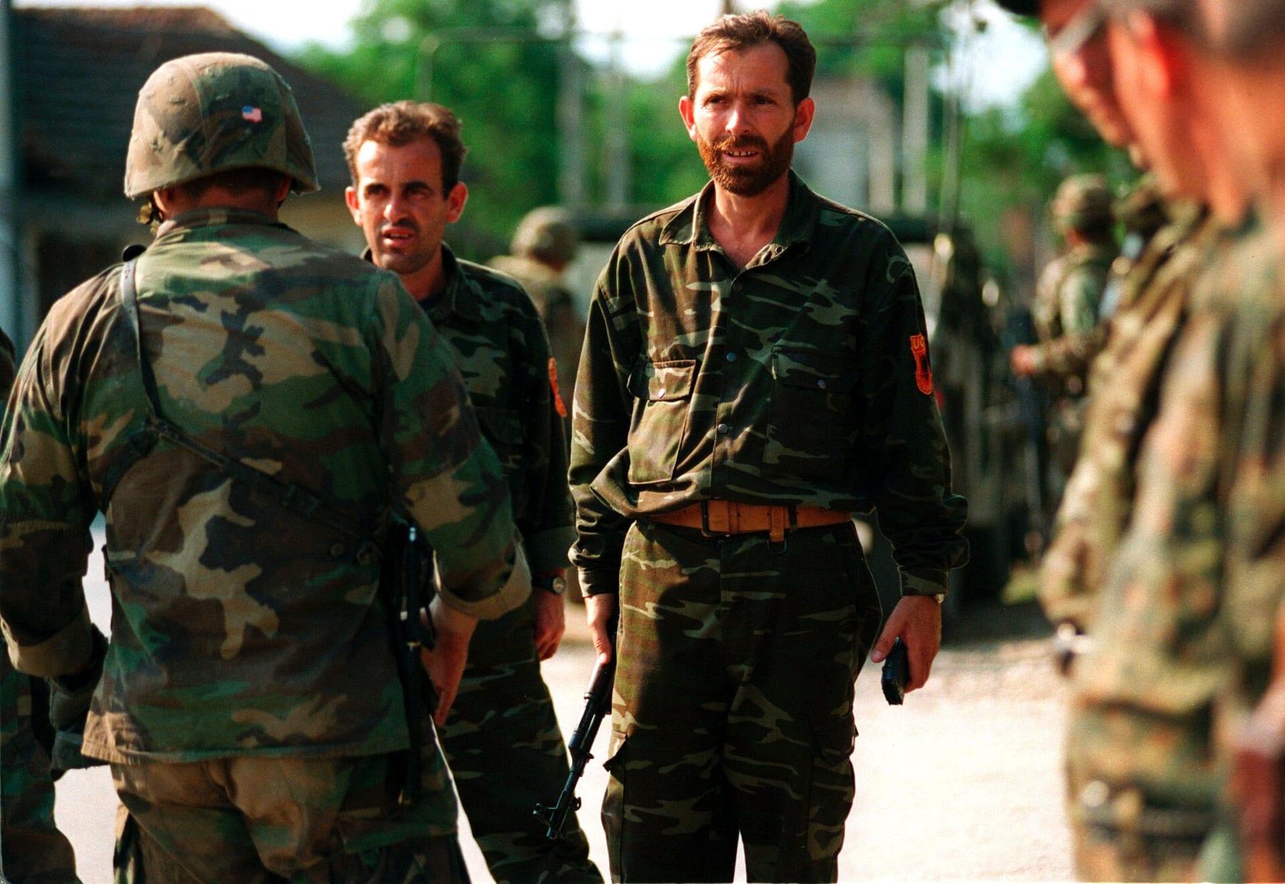 Men in camouflage uniforms lined up facing American soldiers.