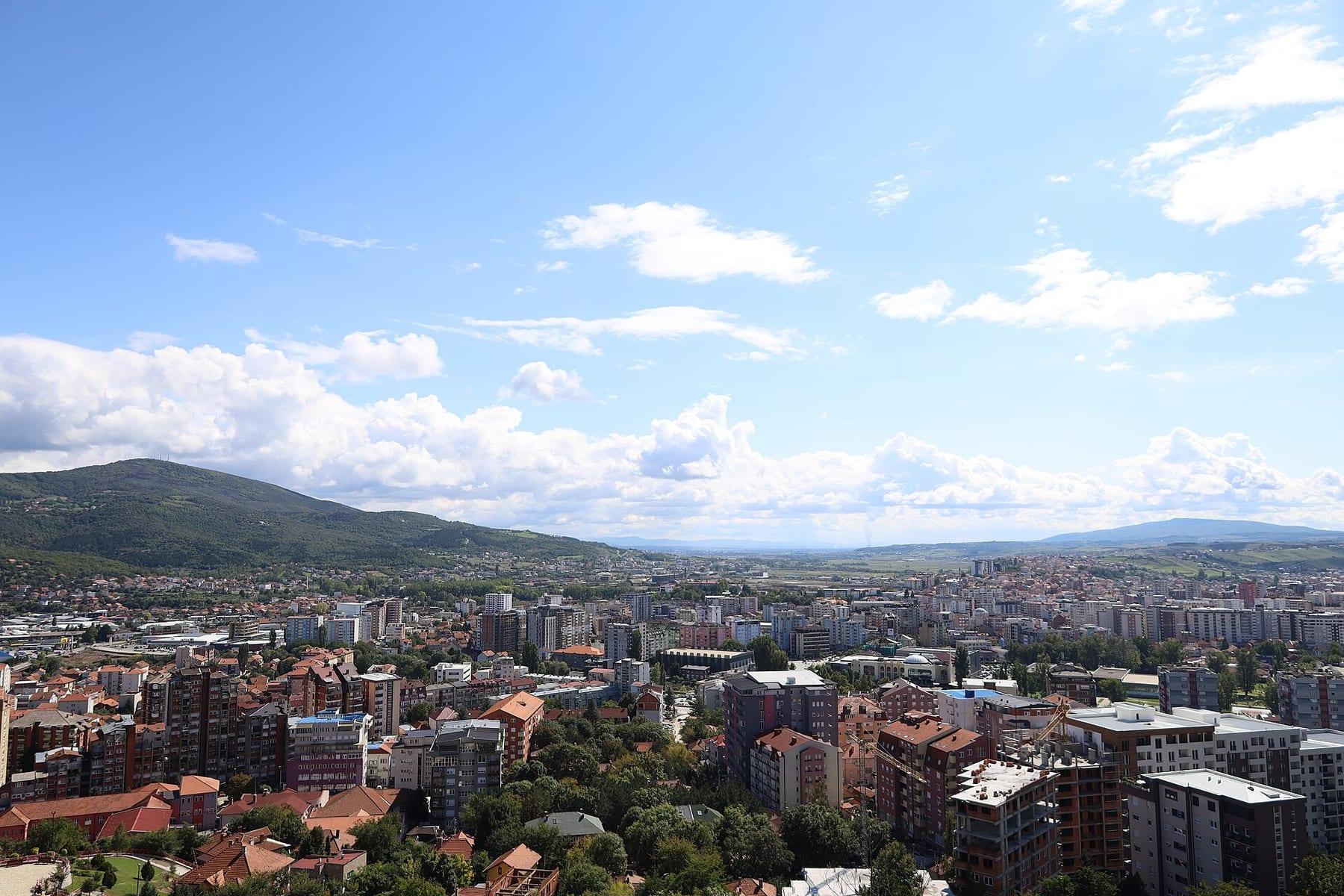 Panorama of the city with apartment blocks and hills on the horizon.
