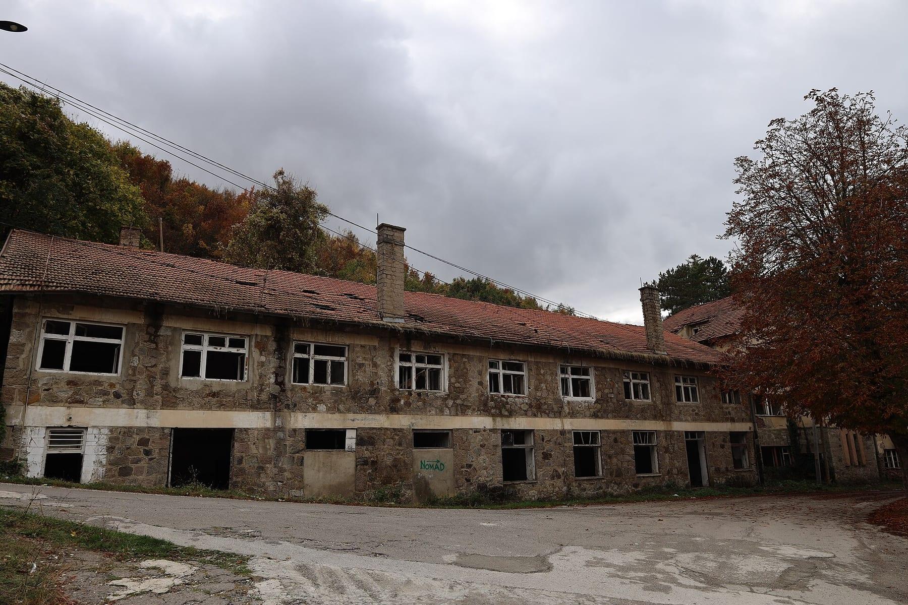 An abandoned old stone building with glassless windows.