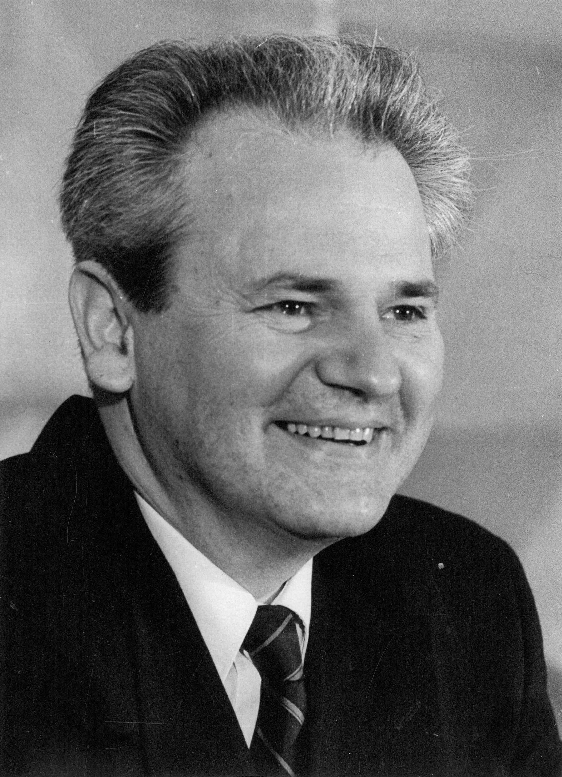 Black-and-white portrait of a man in suit and tie, turned slightly to the side.