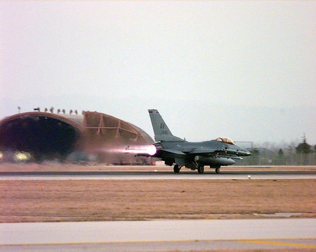 Fighter jet on the runway with afterburner flame during take-off.