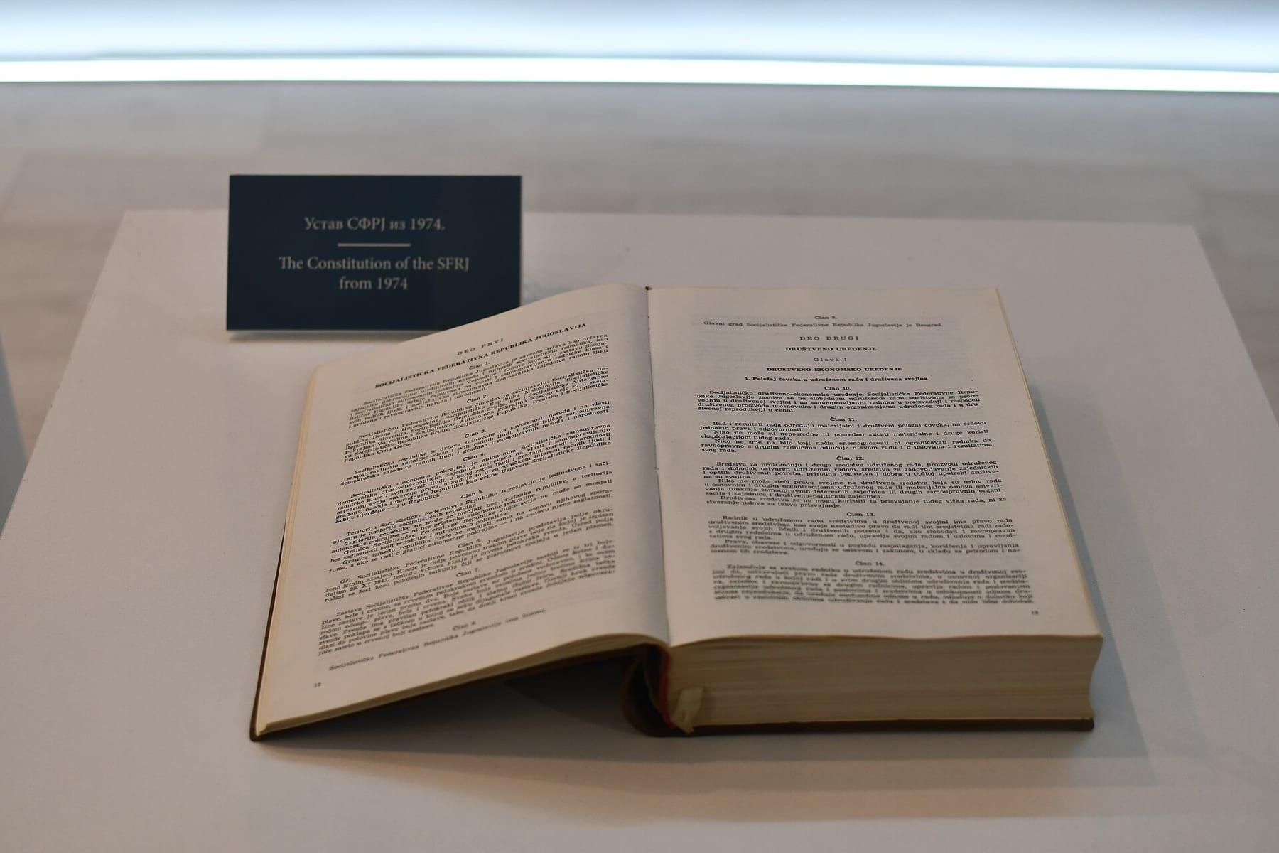 An open book in a museum display with the label “The Constitution of the SFRJ from 1974”.