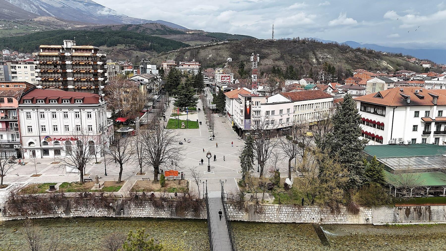 Elevated view of the town centre with square, park and hills behind.