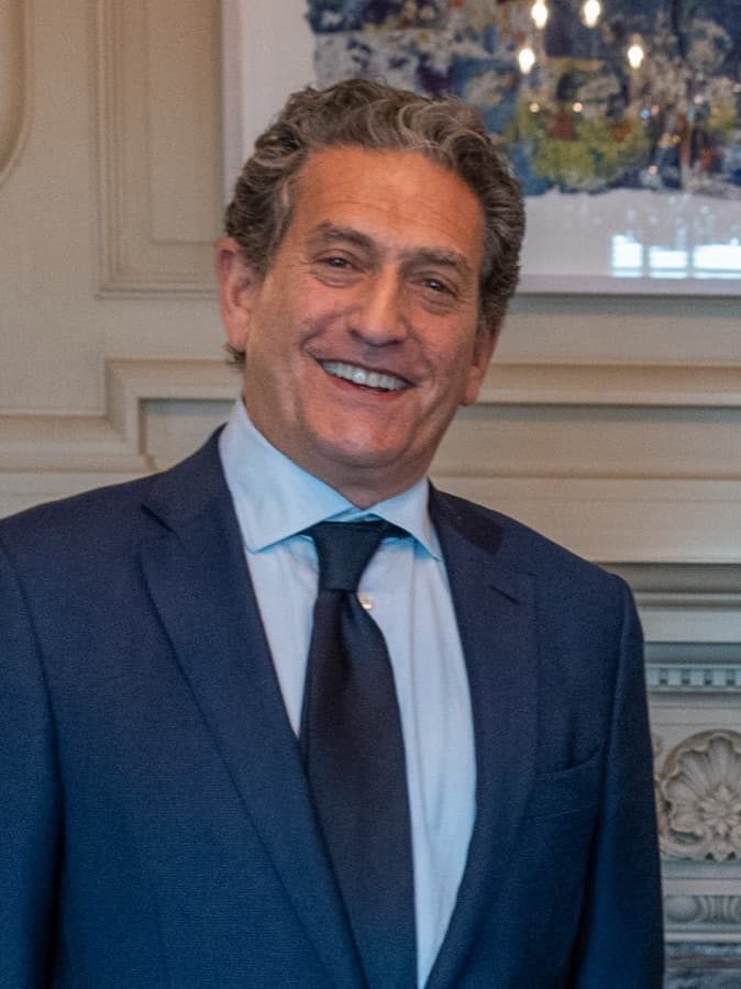 Portrait of a man in a dark suit and tie against a neutral background