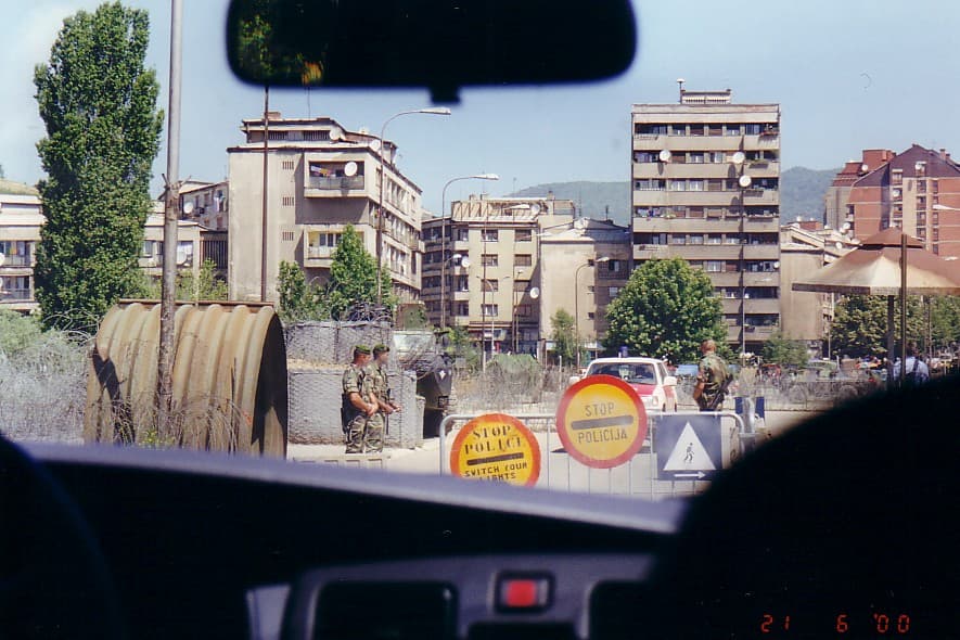 View through a car windscreen towards a checkpoint on a bridge
